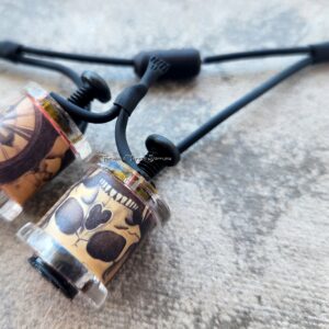 Close-up of two paw print pendants on black cords.