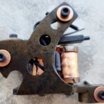 Close-up of a rusty tattoo machine with copper coils.