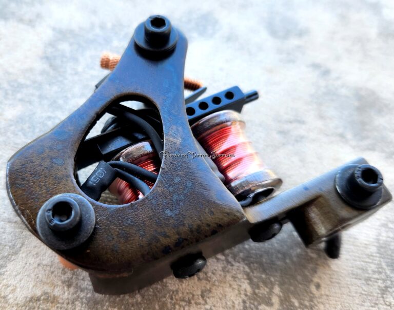 Close-up of a tattoo machine with a red spring coil.