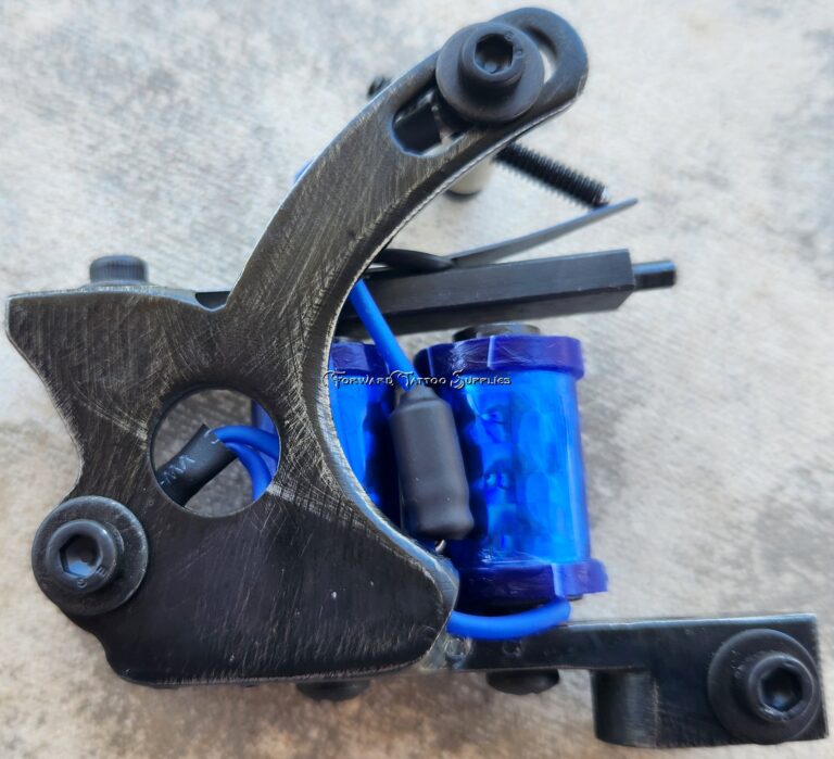 Close-up of a tattoo machine with a blue coil.