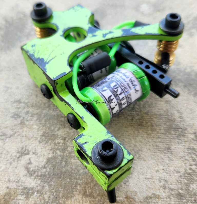 Green tattoo machine on textured surface.