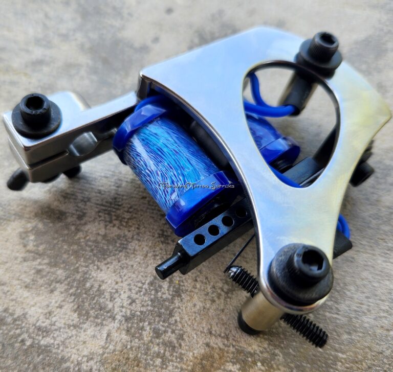 Tattoo machine with blue coils on surface.