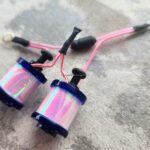 Iridescent tattoo coils with red wires close-up