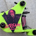 Bright green tattoo machine with scream design.