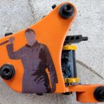Orange tattoo machine featuring a graphic design.