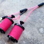 Pink coils and wires on a textured surface.