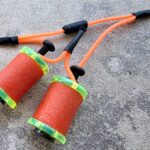 Colorful tattoo machine coils with orange wires.