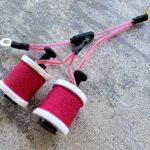 Pink tattoo machine coils with wires and connectors.