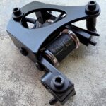 Black tattoo machine with unique design elements.