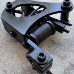Black tattoo machine with textured components visible.