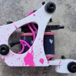 Tattoo machine with white body and pink splatter.