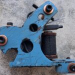 Blue tattoo machine with copper accents.
