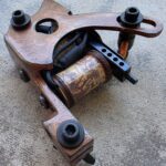 Vintage tattoo machine with intricate design details.